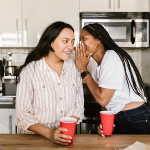 twee vrouwen die in het geheim samen roddelen